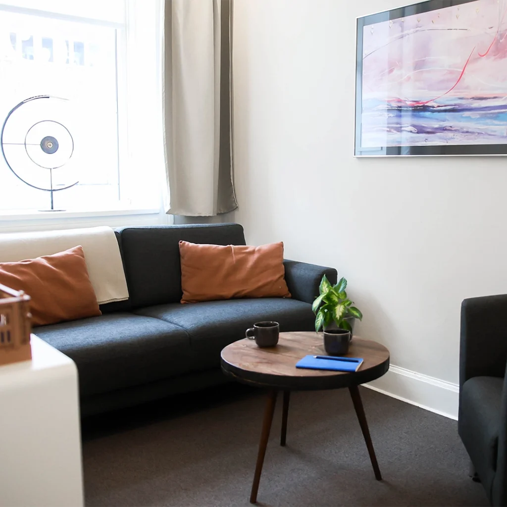 Terapilokale indrettet med sofa og sofastol, klar til at blive taget i brug.