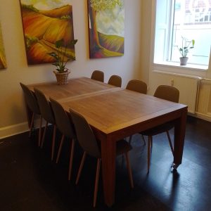 Stort mødebord og kunst på væggene i klinik for terapeuter, beliggende i København.